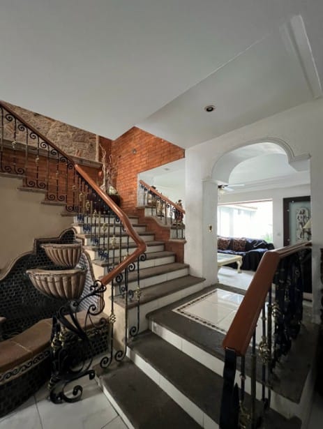 Entrada principal con escalera de mármol y herrería forjada — Casa Condominio Andalucía, Zapopan