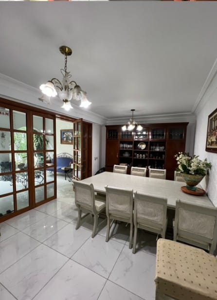 Comedor formal con candil, piso de mármol y acceso al jardín — Casa Andalucía